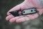 TOPS ALRT XL-03 compact fixed blade knife featuring a black utility blade with a durable angular tip and black canvas micarta handles.